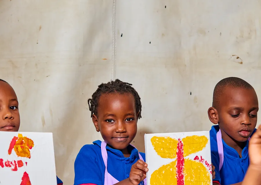 Kindergarten pupils showing their paintings