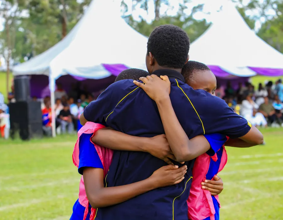 A teacher hugging pupils on sports day
